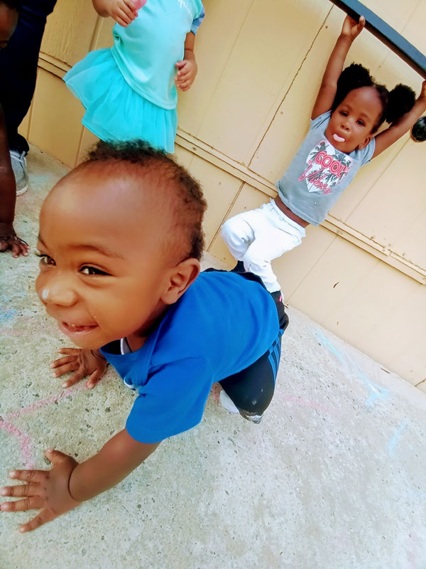 Child crawling with a playful expression.